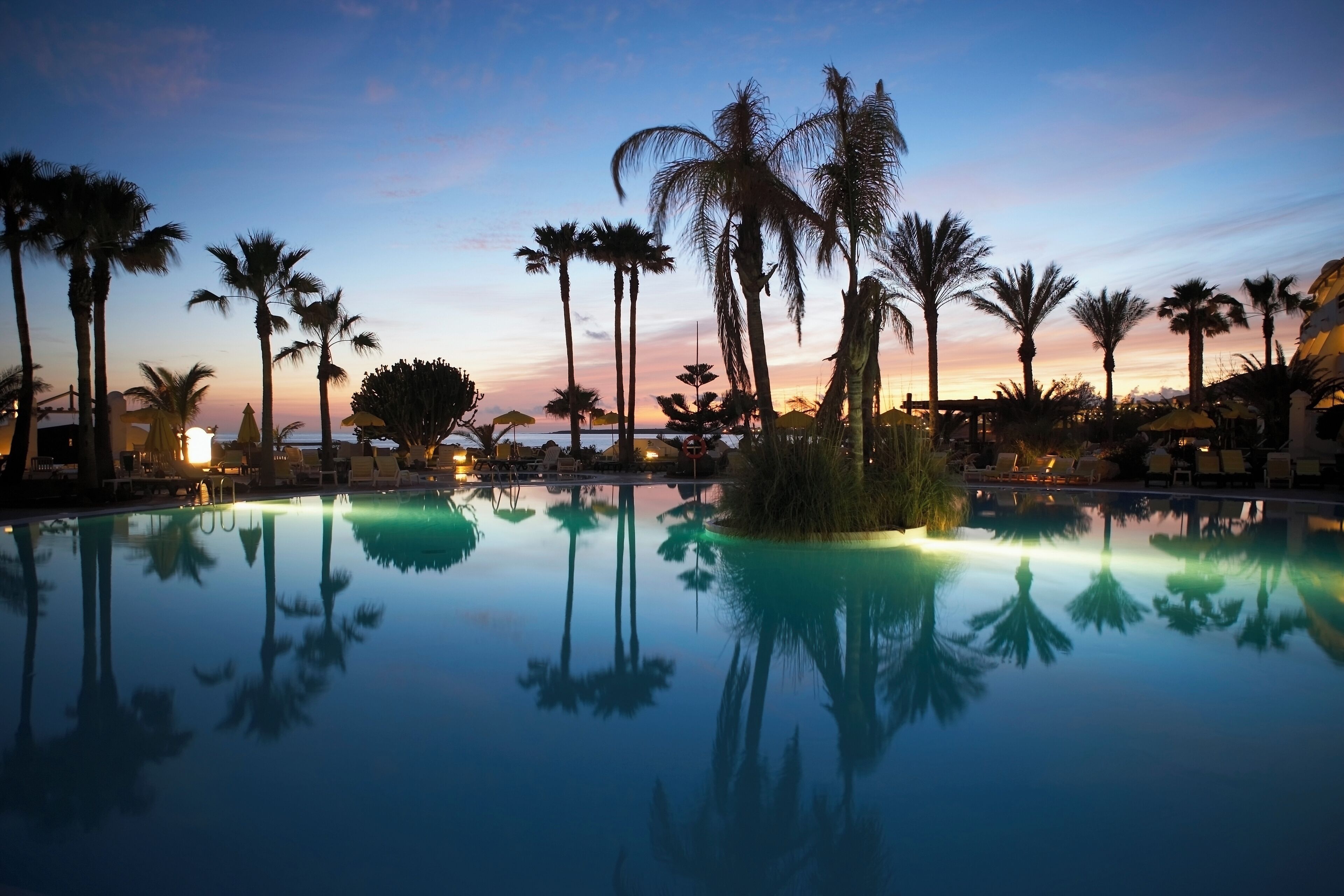 Canary Islands, Lanzarote, swimming pool and palm trees, sunset