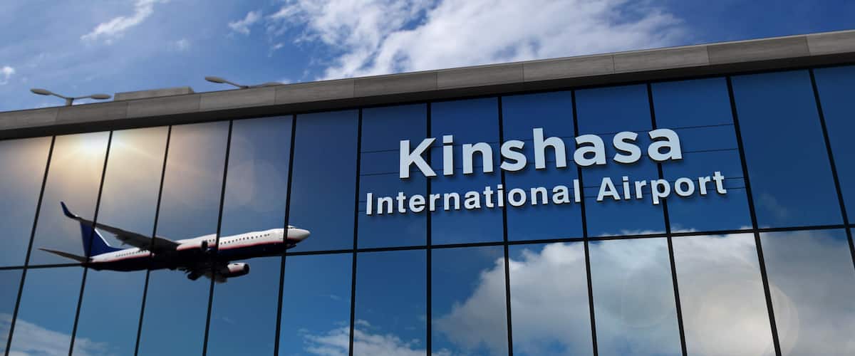 Airplane landing at Kinshasa Congo airport mirrored in terminal