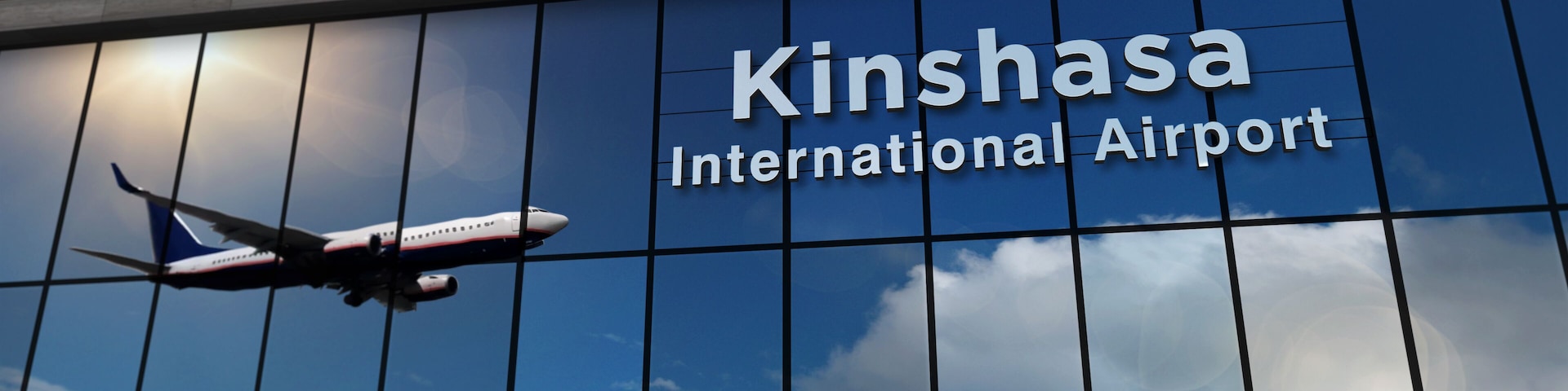 Airplane landing at Kinshasa Congo airport mirrored in terminal