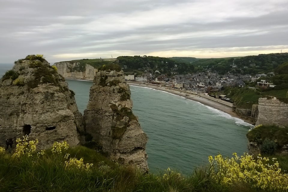 Une ville côtière avec des falaises, une plage et une vue sur la mer.