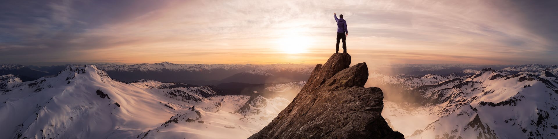 Magical Fantasy Adventure Composite of Man Hiking on top of a rocky mountain peak. Background Landscape from British Columbia, Canada. Sunset or Sunrise Colorful Sky