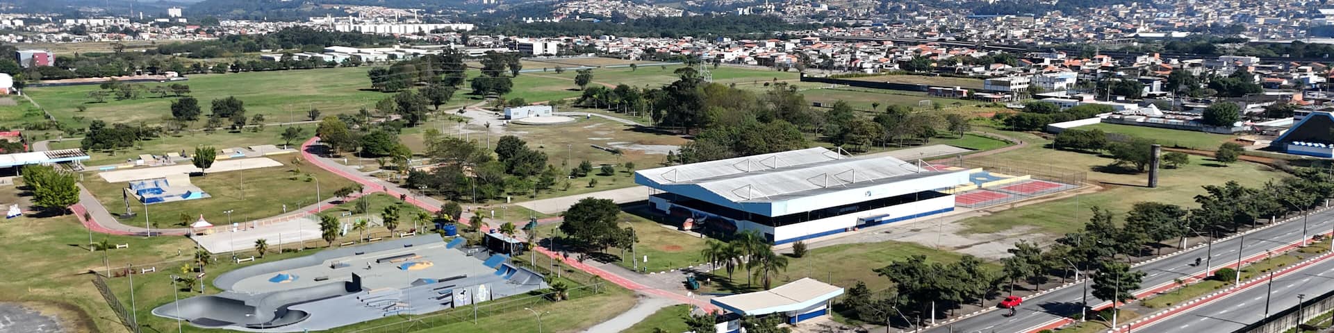 Imagem aérea do parque Max Feffer em Suzano, com áreas verdes, pista de caminhada, praça de eventos e paisagismo urbano
