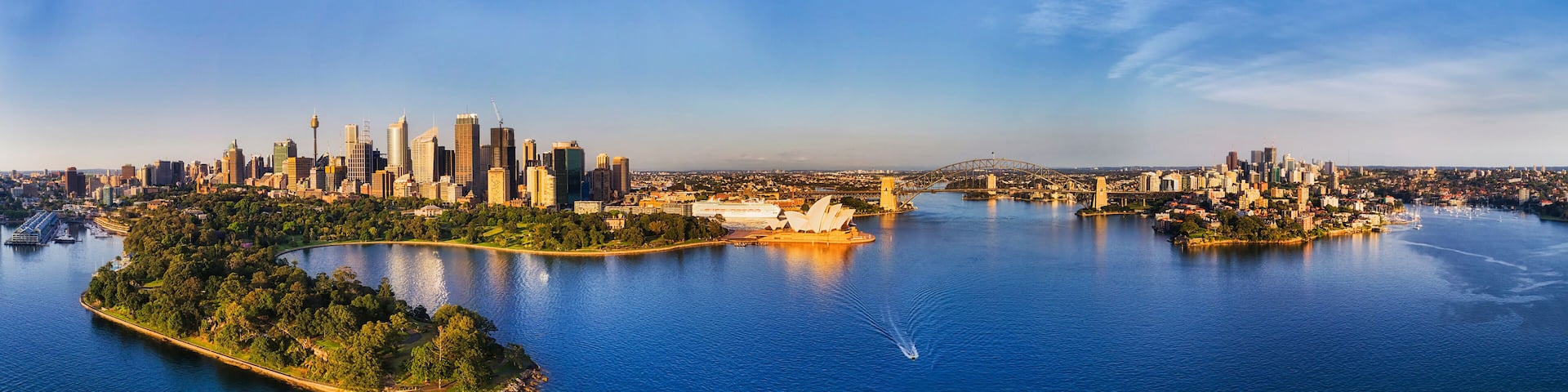A city skyline with a prominent bridge and a large body of water.
