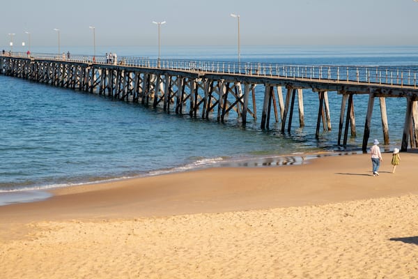 Port Noarlunga Jetty featuring general coastal views and a beach as well as a family