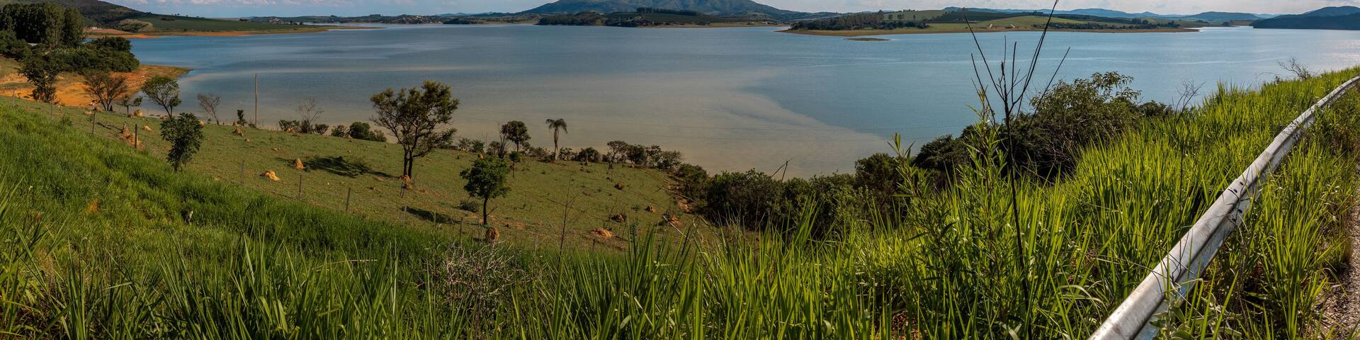 A large lake surrounded by hills and greenery.