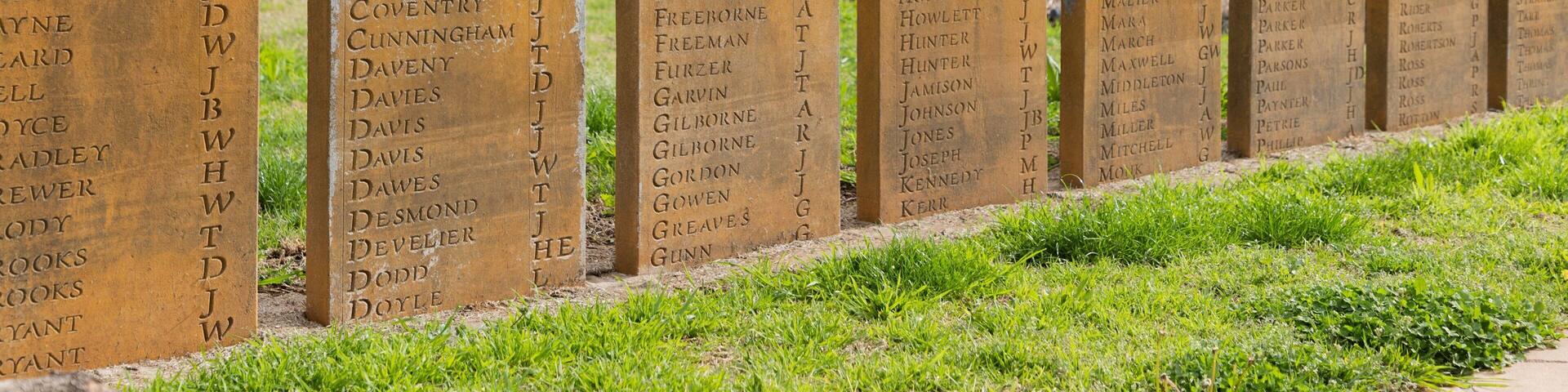 A row of headstones with engraved names.
