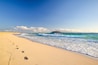 Stunning morning view of the islands of Lobos and Lanzarote seen from Corralejo Beach (Grandes Playas de Corralejo) on Fuerteventura, Canary Islands, Spain, Europe. Beautiful footprints in the sand.