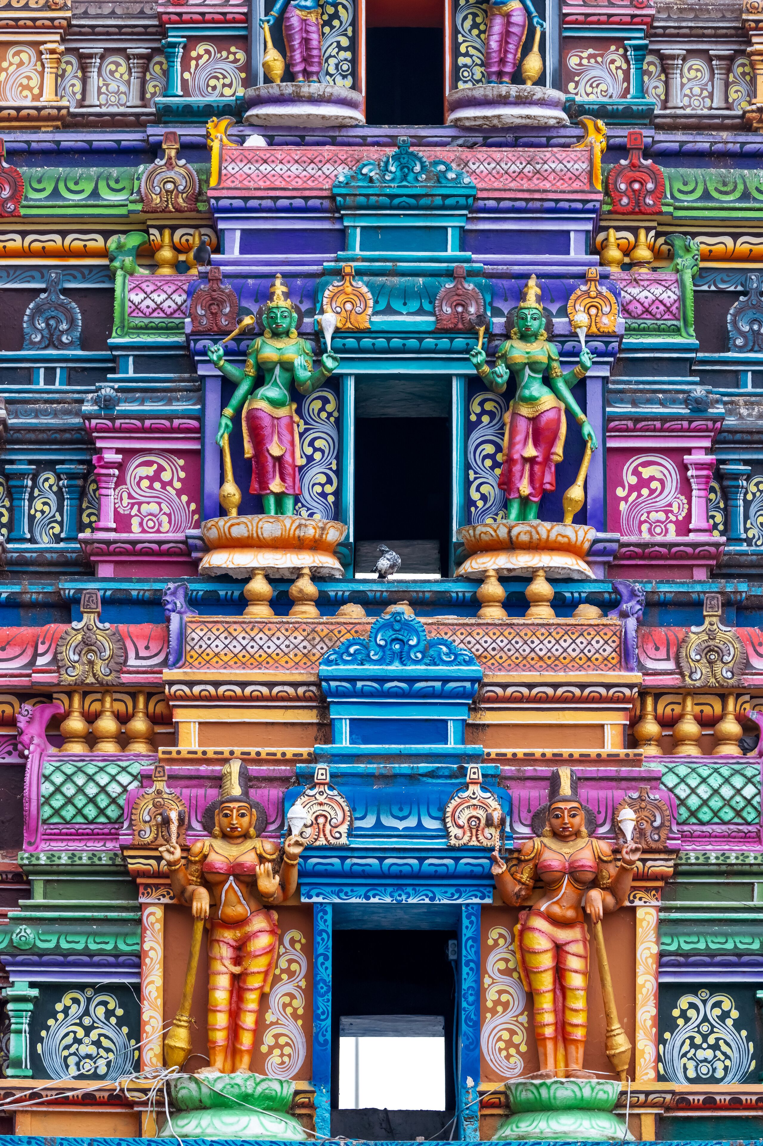 A colorful temple facade with intricate carvings and statues.