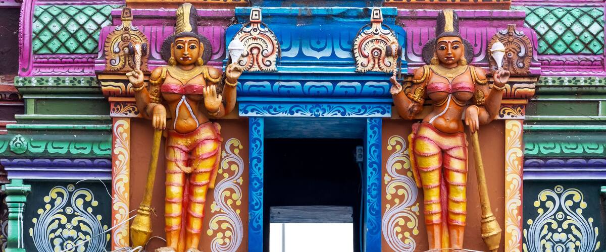 A colorful temple facade with intricate carvings and statues.