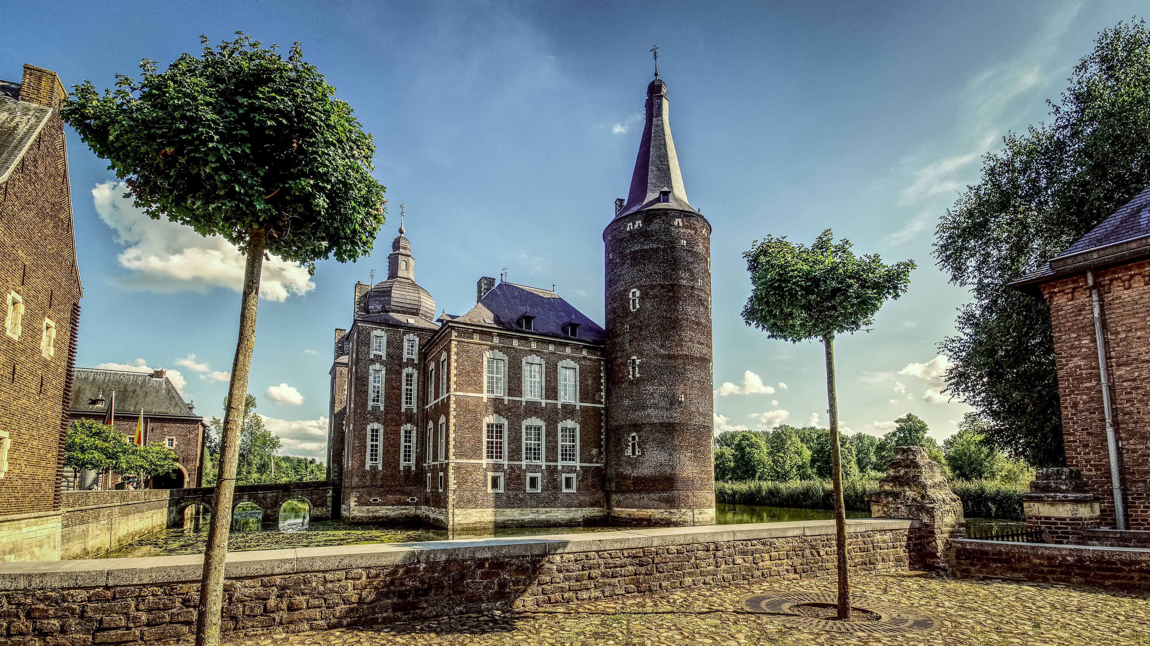 A historic building with a tall tower and a smaller building with a sloped roof.
