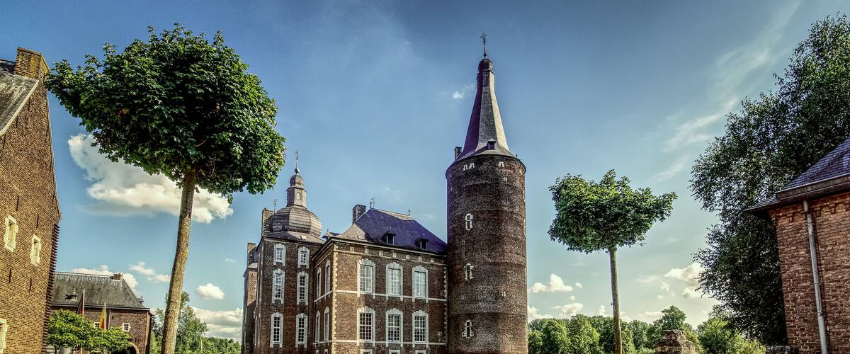A historic building with a tall tower and a smaller building with a sloped roof.