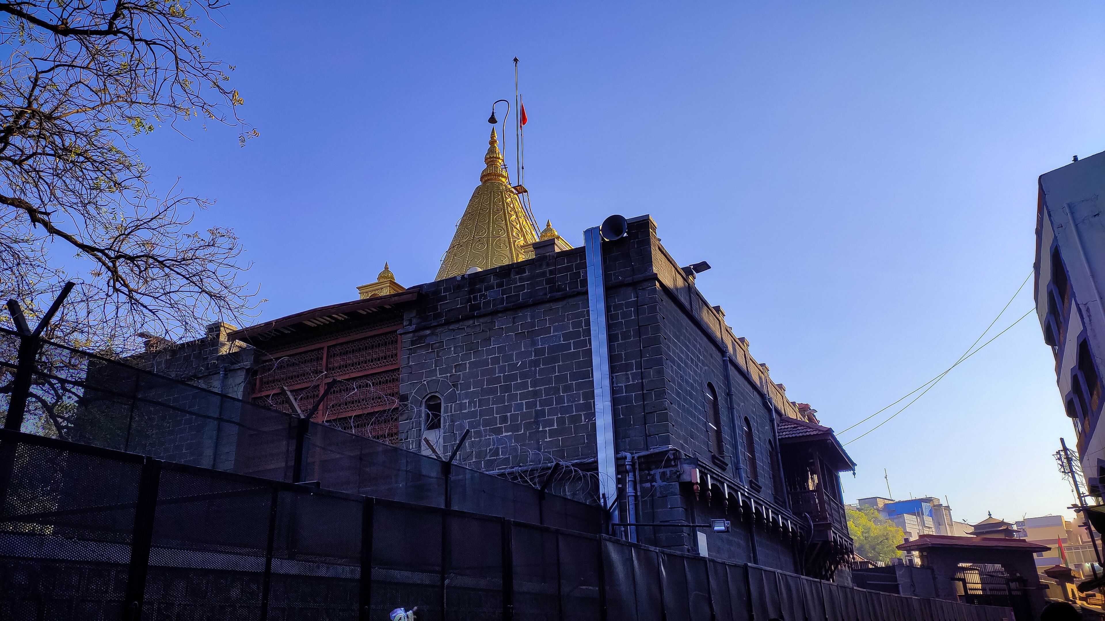 A historic building with a golden spire and a flagpole.