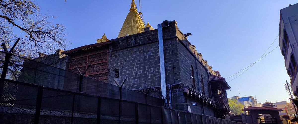 A historic building with a golden spire and a flagpole.