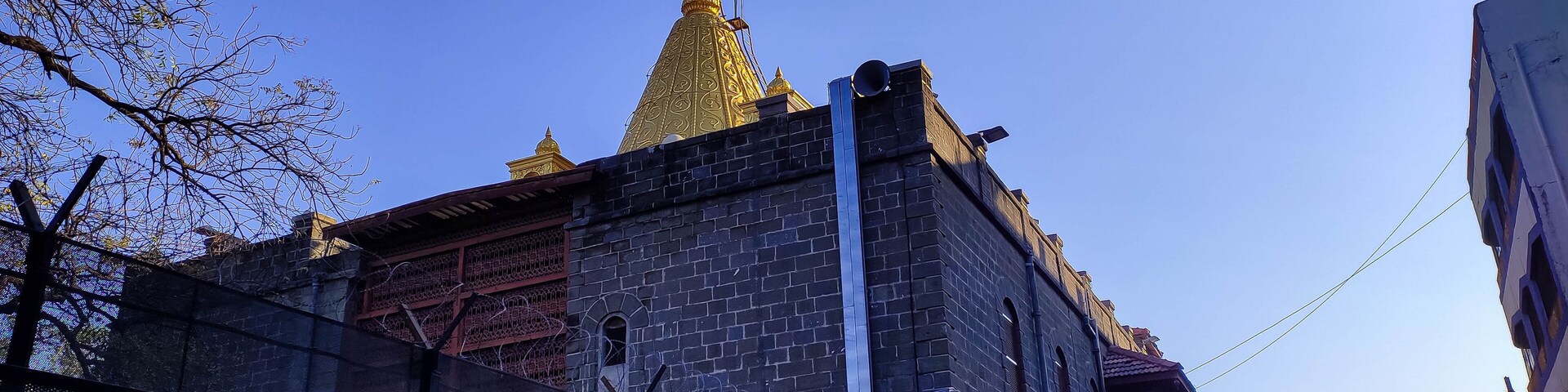 A historic building with a golden spire and a flagpole.