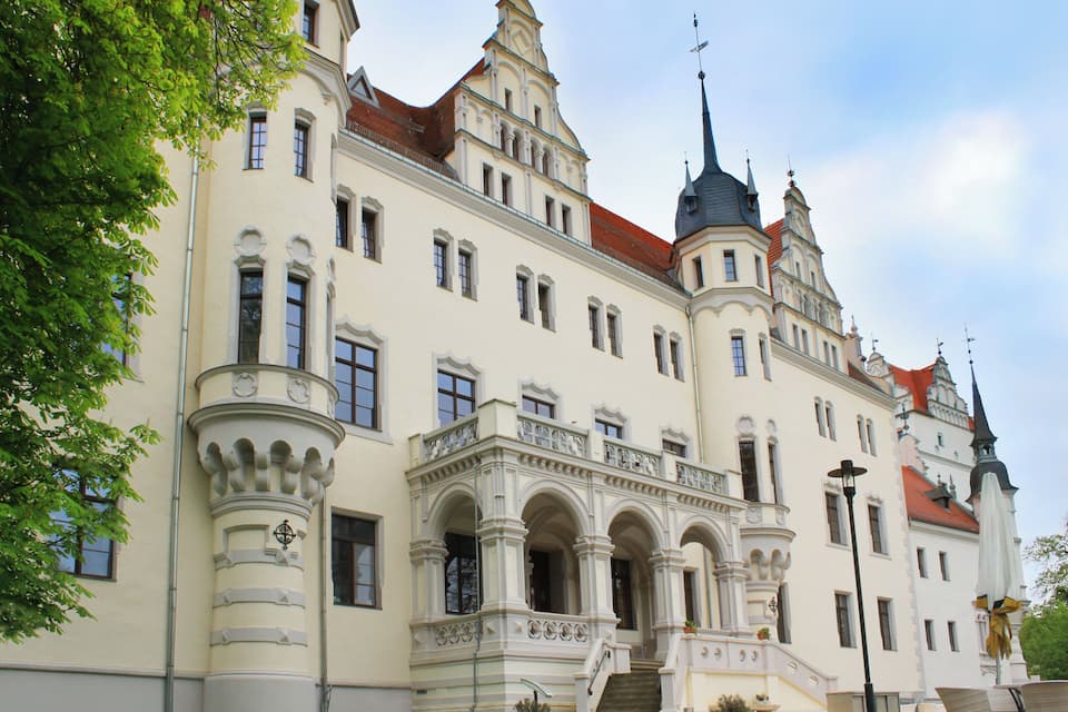 Ein großes, verziertes Gebäude mit mehreren Türmen und einem roten Dach.