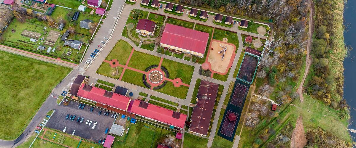 Top view of the autumn forest. The Volga river in the Staritsky district of the Tver region, Russia. Manor and village.