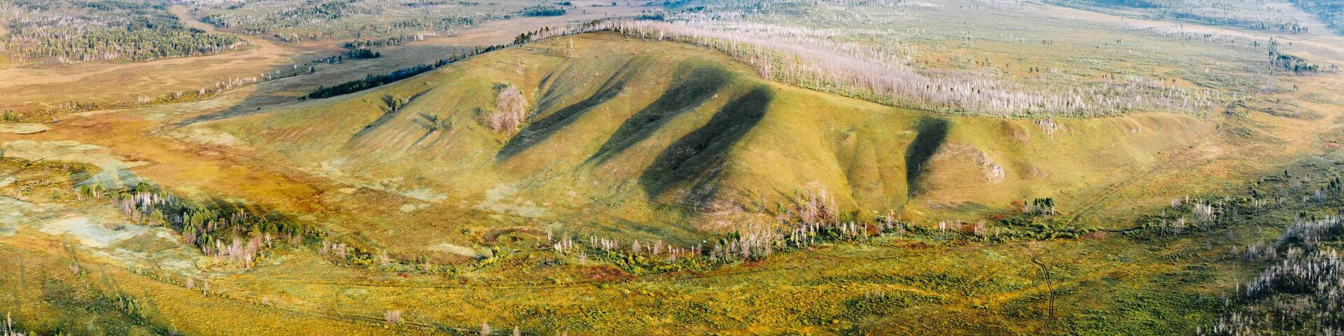 Panorama of siberian taiga in Zabaykalsky Krai, Russia with hills, swamps, and trees, high angle aerial view. Wild nature landscape in Far East, Asia