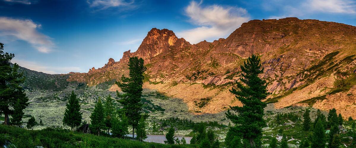 Gorgeous panoramic view on top of western Sayan mountain range during summer sunset in Ergaki national park, Siberia, Russia