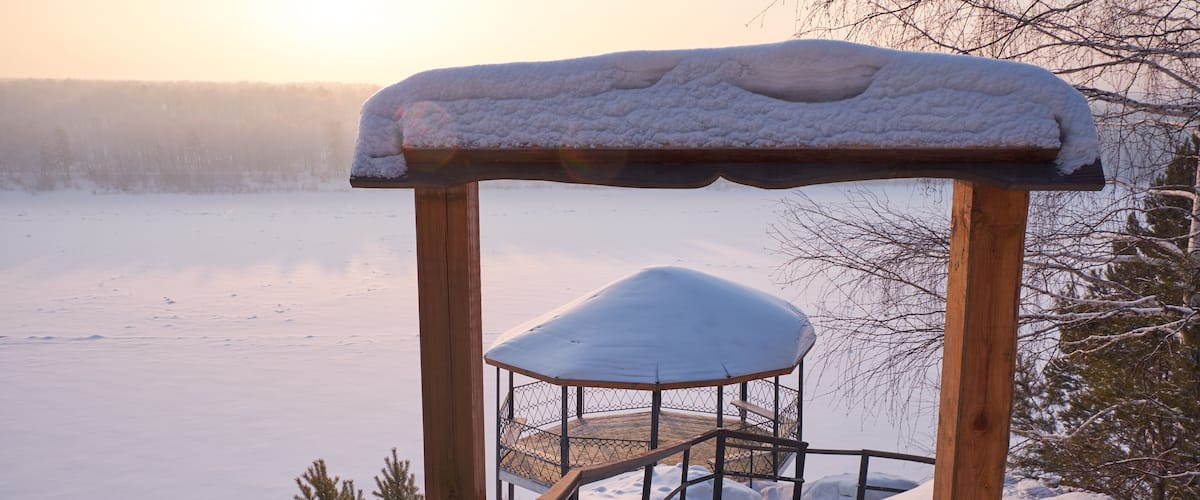 Gazebo over the river Tom covered by snow in winte