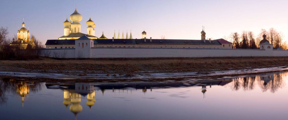 Tikhvin assumtion monastery. Russian Orthodox monastery founded in 1560. Evening beautiful landscape with a lighted monastery. Panorama. Tikhvin, Leningrad region, Russia