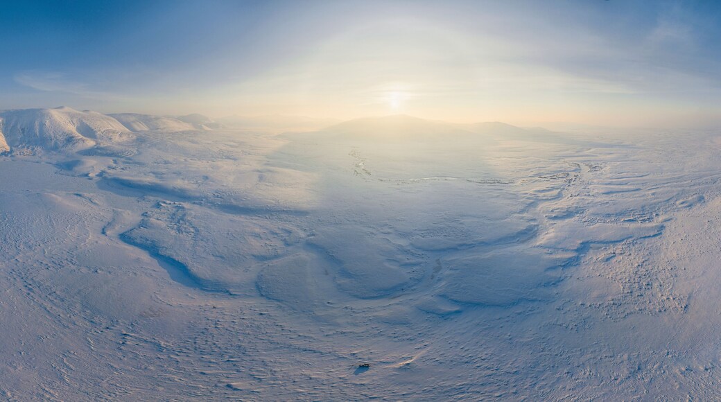 Aerial view of cold, snowy tundra landscape with beautiful mountain peaks, Vorkuta, Komi Republic, Russia.