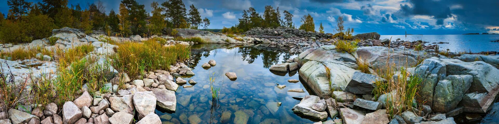 Russia. Karelia. The rocky shore of the island. Rocky river. Large stones flooded with water. Karelian landscape. Wildlife panorama. Stony shore on Lake Ladoga. Ladoga lake.