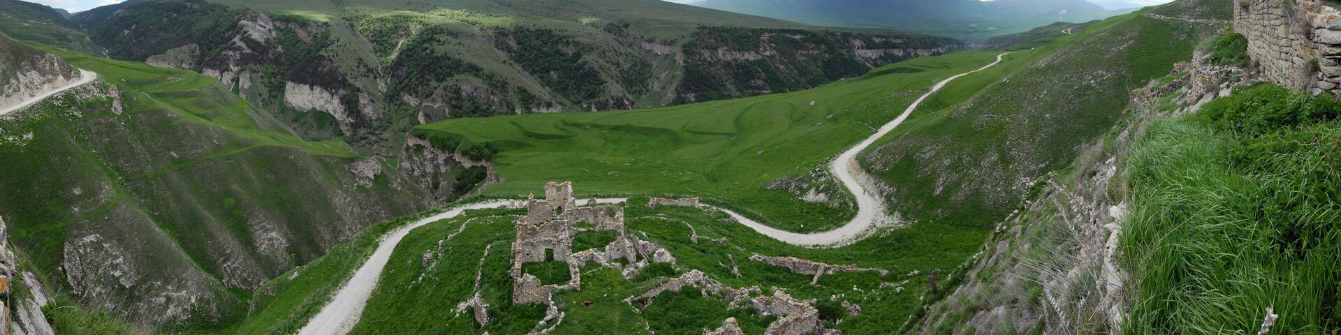 Mountainous landscape. Local road goes along the Ahkhete river canyon passing the ruined medieval fortress. Chechnya (Chechen Republic), Russia, Caucasus.
