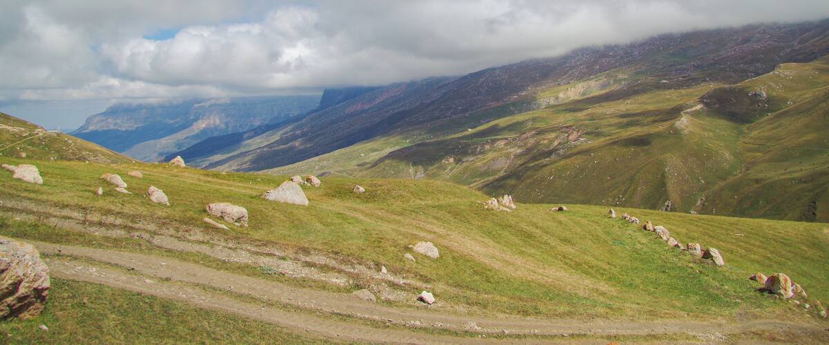 Autumn mountain landscape. Scenic view of the alpine pasture and Mount Erydag. Red rock Erydag (3925 m) - popular place of mountaineering. Russia, North Caucasus, Dagestan, Dokuzparinsky District