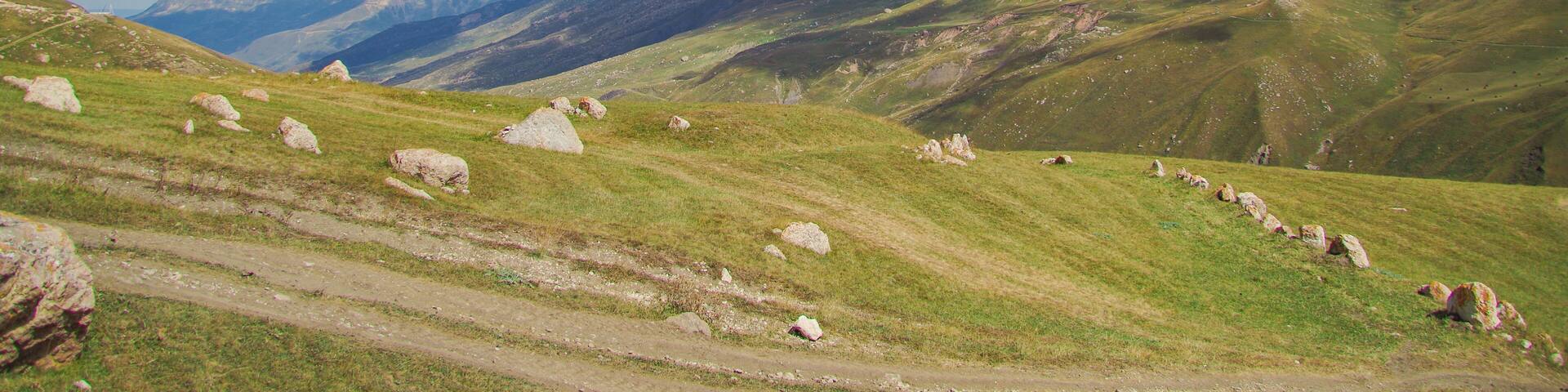 Autumn mountain landscape. Scenic view of the alpine pasture and Mount Erydag. Red rock Erydag (3925 m) - popular place of mountaineering. Russia, North Caucasus, Dagestan, Dokuzparinsky District