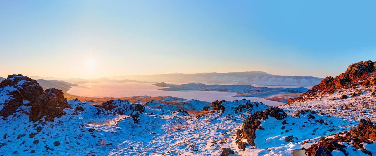 Beautiful winter landscape of frozen Baikal Lake. Panoramic view of the natural landmark of Olkhon Island at sunset - Baikal lake, Siberia