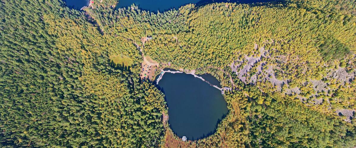 Three lakes surrounded by autumn forest from the air.