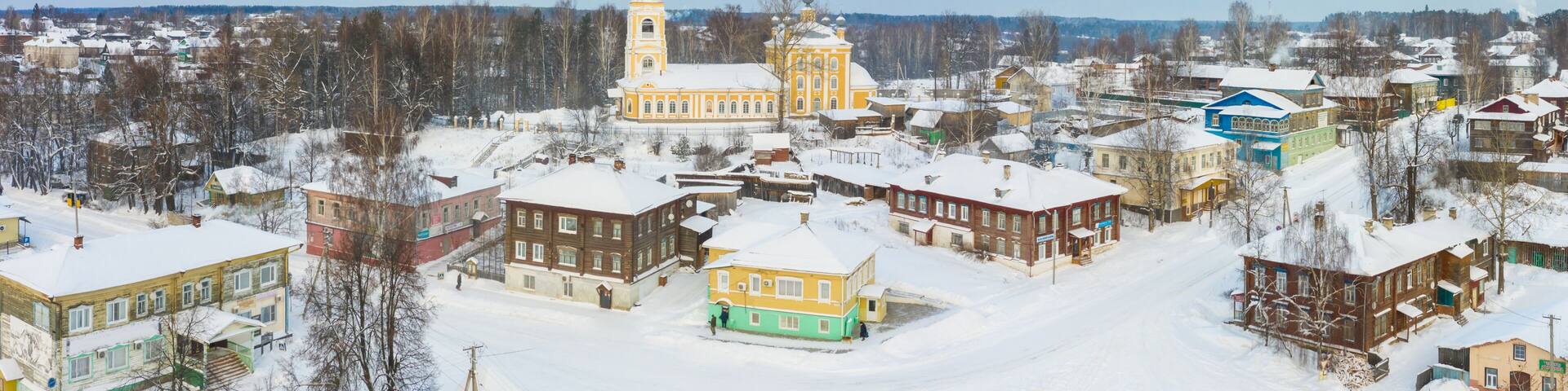 Panorama of a small city in the depths of Russia from a height. Orthodox churches and traditional old wooden houses, Kologriv in the Kostroma region and a winter view of the city