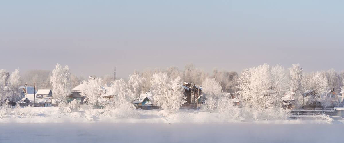 Winter landscape, white snow covered on trees and local houses in urban countryside, in Russia