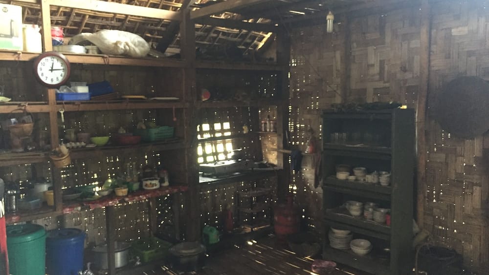 A rustic interior with wooden shelves, a clock, and various kitchen items.