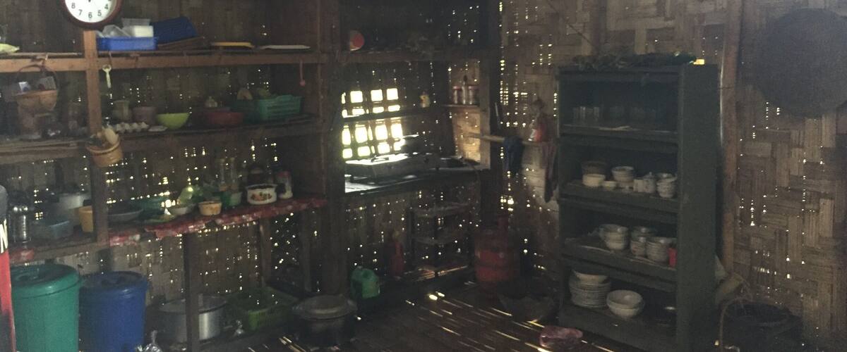 A rustic interior with wooden shelves, a clock, and various kitchen items.