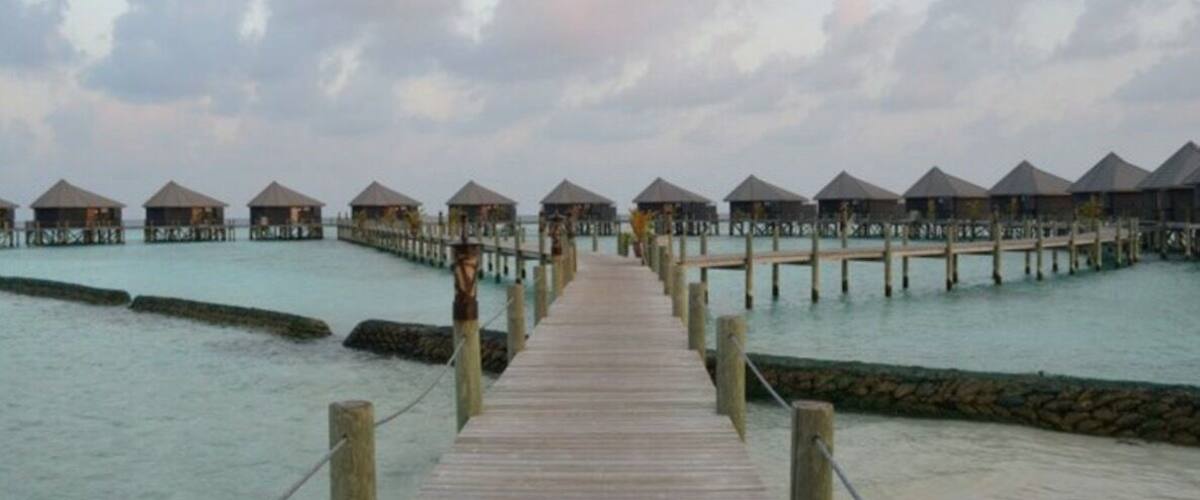 A wooden pier leading to overwater bungalows.