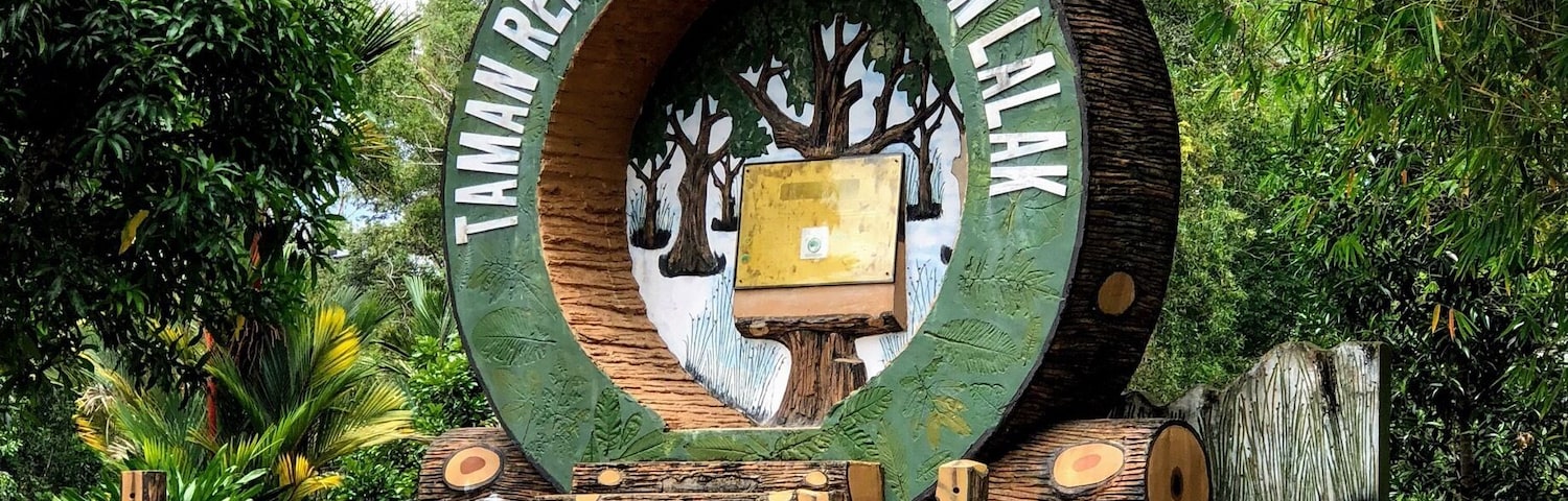 Una estructura de madera circular con un letrero que dice 'TAMAN REKREASI HUTAN LUAGAN LAK'.