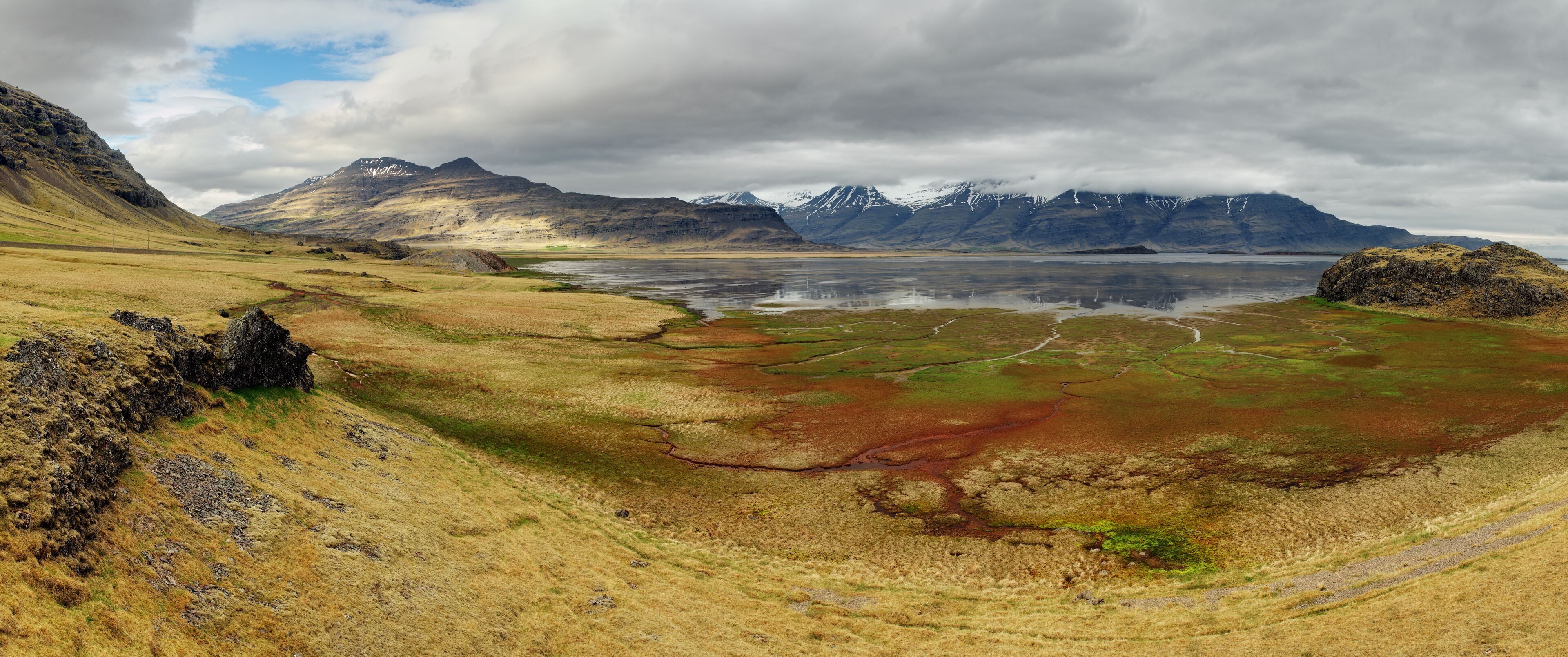 A mountainous landscape with a lake and a road.