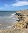 Une côte rocheuse où les vagues s’écrasent sur le rivage.