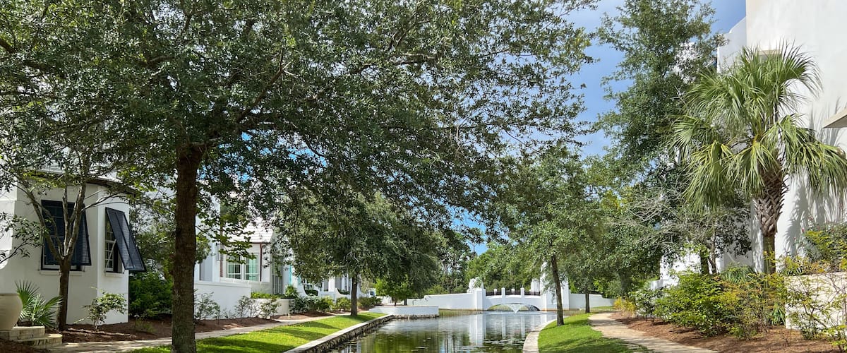 A walking path with water feature and homes in Alys Beach, Florida.