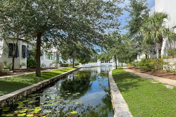 A walking path with water feature and homes in Alys Beach, Florida.