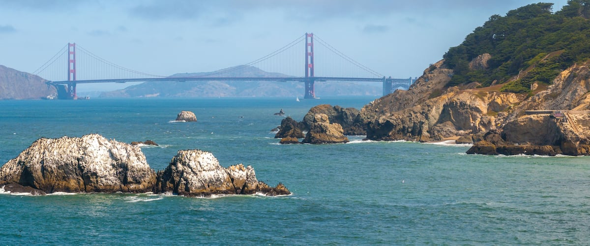 Where the sea meets the land in San Francisco. Ocean Beach is a world renowned surfing beach in the Sunset district of San Francisco. Cliff house building on the cliffs.