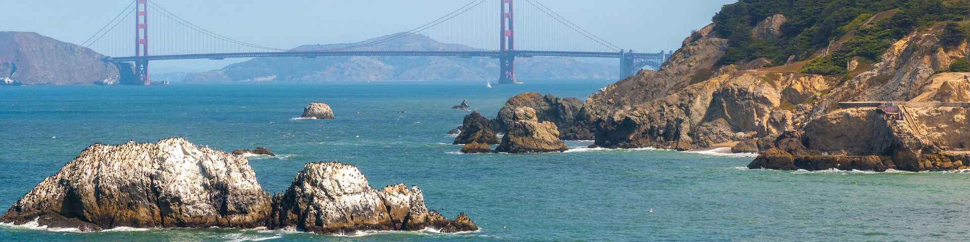 Where the sea meets the land in San Francisco. Ocean Beach is a world renowned surfing beach in the Sunset district of San Francisco. Cliff house building on the cliffs.