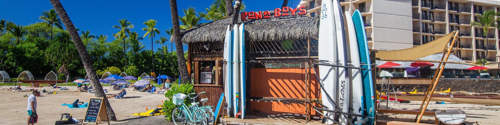 A beachside restaurant named 'Kona Boys' with surfboards and bicycles.