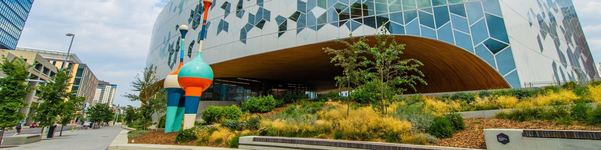 A modern building with a geometric facade and a curved entrance.