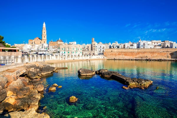 Panoramic view of Monopoli from the city beach of Cala Porta Vecchia, province of Bari, Puglia (Apulia), Italy, Europe. Monopoli seaside of Adriatic Sea, Puglia, Italy. Architecture of Monopoli