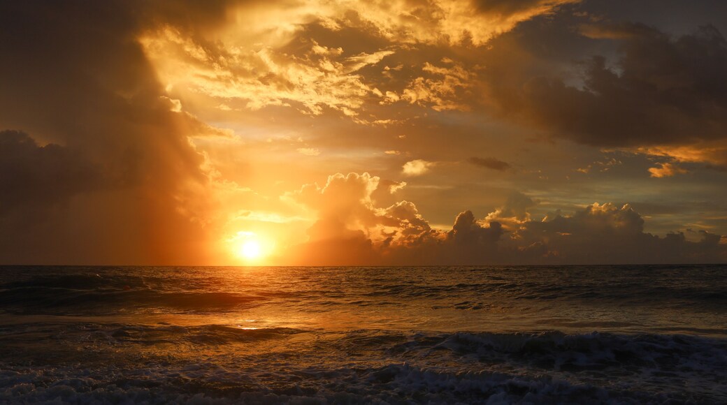 Dreamy Sunrise in Vero Beach, Florida over Atlantic Ocean at an Oceanfront Resort. Yellow Orange Clouds. Sunrise over Atlantic Ocean reflecting on waves beach at Dawn.