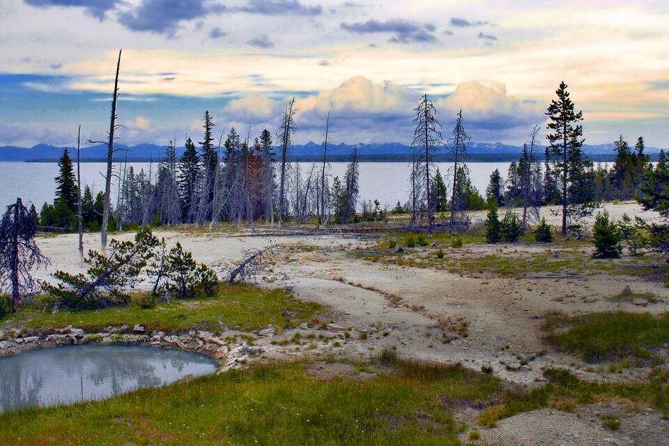 A lake surrounded by trees and mountains.
