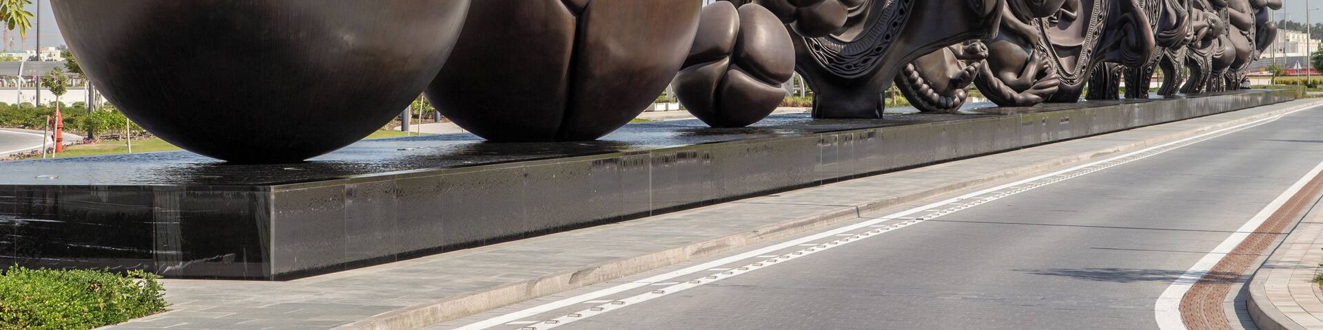Una gran escultura de figuras abstractas sobre un puente.