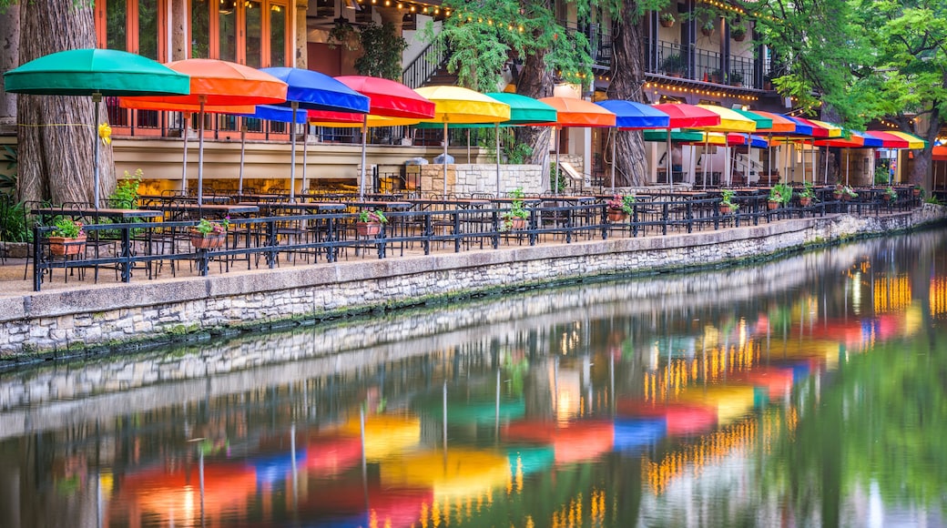 A riverside café with colorful umbrellas and tables.